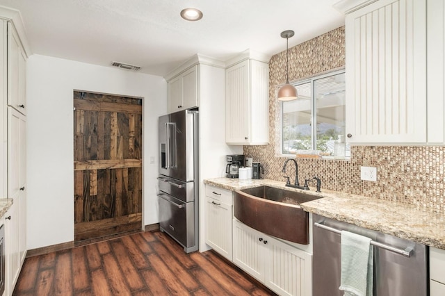 kitchen with dark wood-style flooring, stainless steel appliances, tasteful backsplash, visible vents, and a sink