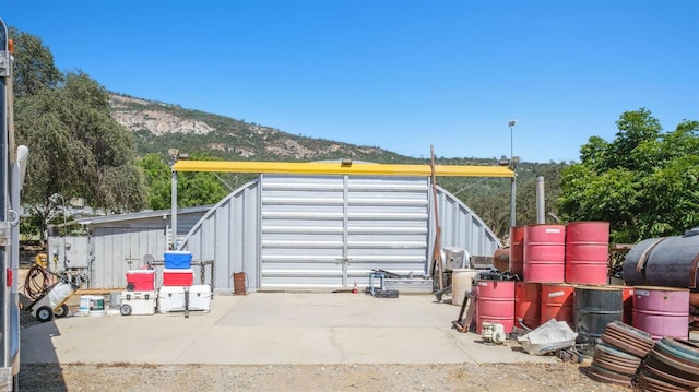 view of outbuilding featuring a mountain view and fence