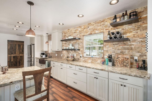 kitchen featuring open shelves, backsplash, freestanding refrigerator, and white cabinetry