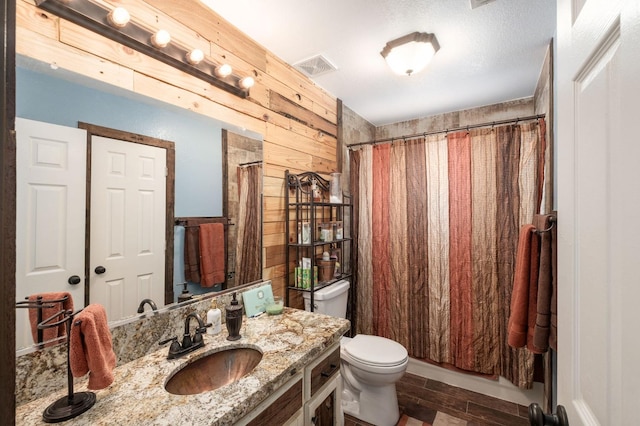 full bathroom featuring wooden walls, visible vents, toilet, wood finished floors, and vanity