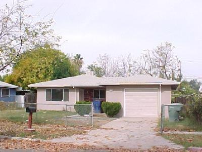 ranch-style house with a garage, concrete driveway, fence, and stucco siding