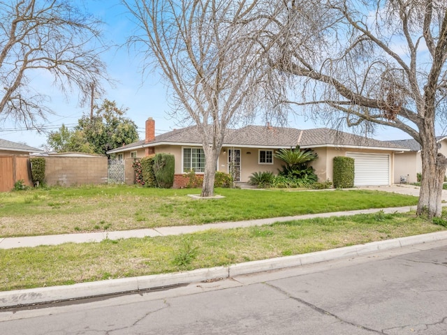 single story home with stucco siding, a front yard, fence, a garage, and driveway