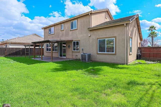 back of house with a lawn, a patio area, a fenced backyard, and stucco siding