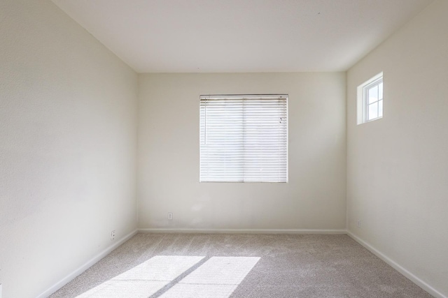 carpeted spare room featuring baseboards