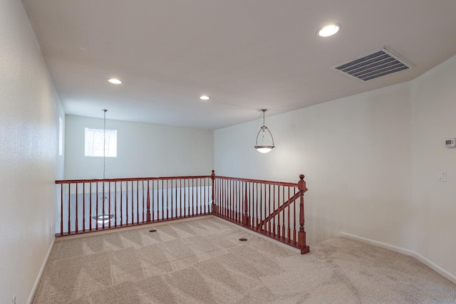 unfurnished room with carpet, visible vents, baseboards, and recessed lighting