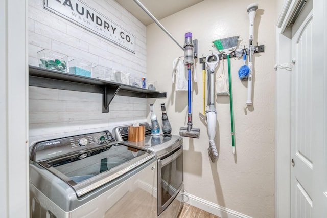 laundry area with laundry area, independent washer and dryer, baseboards, and wood finished floors