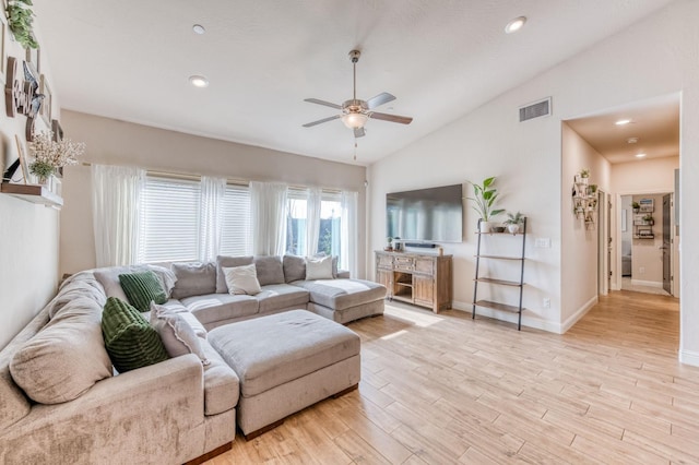 living area with baseboards, visible vents, a ceiling fan, lofted ceiling, and light wood-type flooring