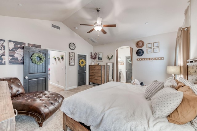 bedroom featuring lofted ceiling, light carpet, visible vents, and arched walkways