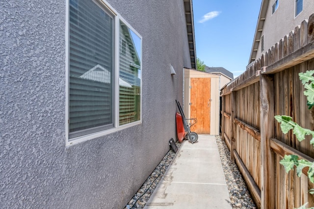 view of side of property with fence and stucco siding