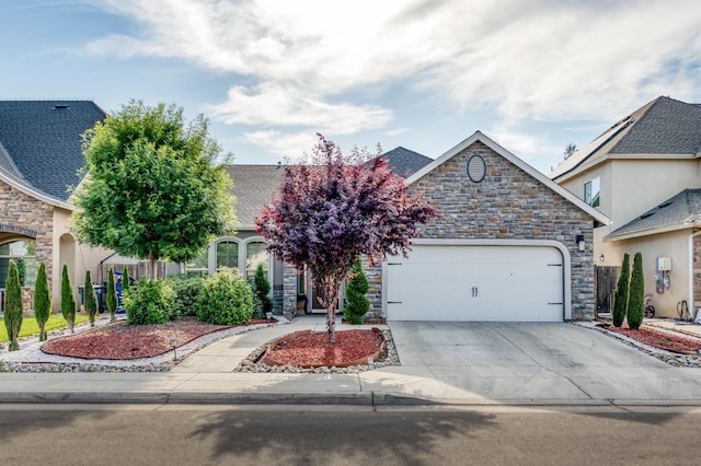 obstructed view of property with a garage, stone siding, and concrete driveway