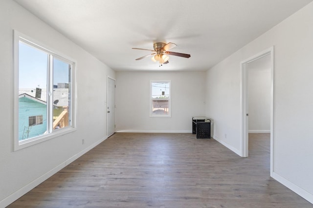 spare room with ceiling fan, baseboards, and wood finished floors