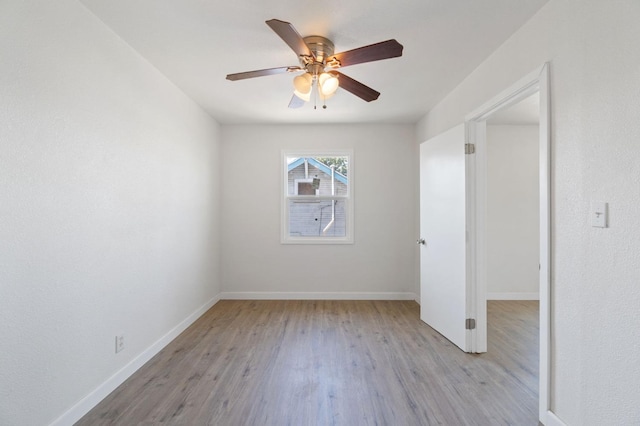 unfurnished room with a ceiling fan, baseboards, and wood finished floors