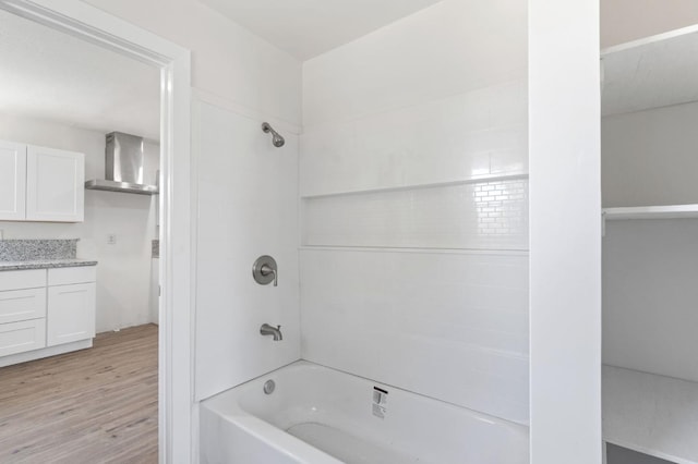 bathroom with wood finished floors, bathtub / shower combination, and vanity