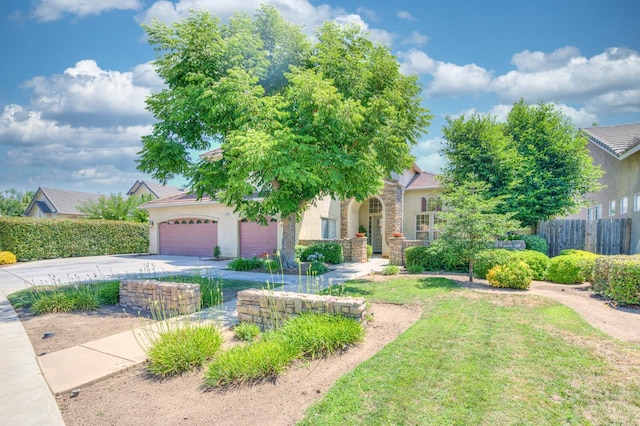 view of property hidden behind natural elements with stucco siding, fence, a garage, driveway, and a front lawn