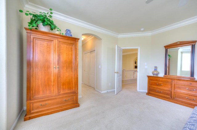 bedroom with baseboards, arched walkways, crown molding, and light colored carpet