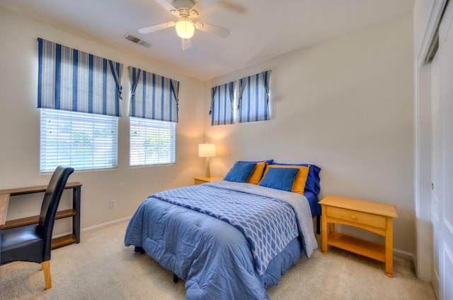 carpeted bedroom with baseboards, visible vents, and a ceiling fan