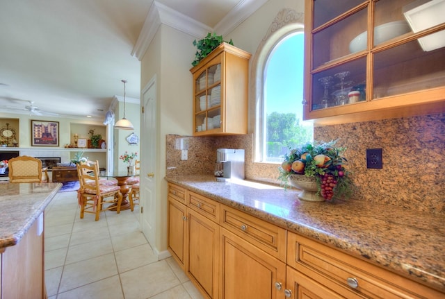 kitchen featuring light tile patterned floors, ornamental molding, backsplash, and light stone countertops