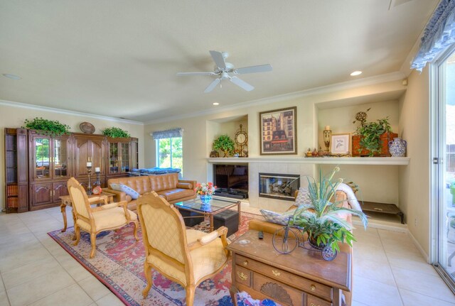 3033 Hanson Ave, Clovis, CA 93611 - living area featuring light tile patterned floors, ceiling fan, a tiled fireplace, crown molding, and recessed lighting