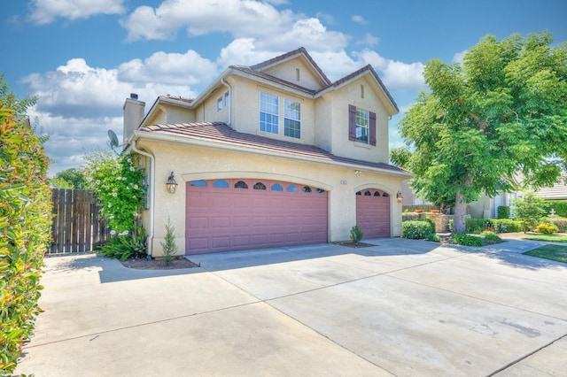 view of front of property featuring a chimney, stucco siding, an attached garage, fence, and driveway