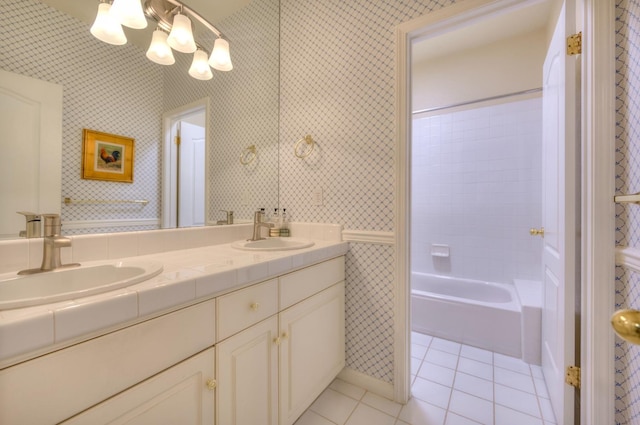 bathroom with double vanity, tile patterned flooring, a sink, and wallpapered walls