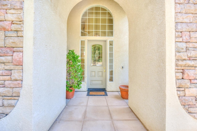 doorway to property featuring stucco siding