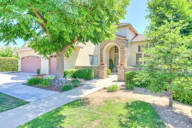 3033 Hanson Ave, Clovis, CA 93611 - view of front of home featuring stucco siding, stone siding, driveway, a garage, and a tiled roof