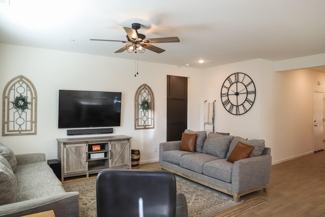 living room featuring a ceiling fan, baseboards, wood finished floors, and recessed lighting