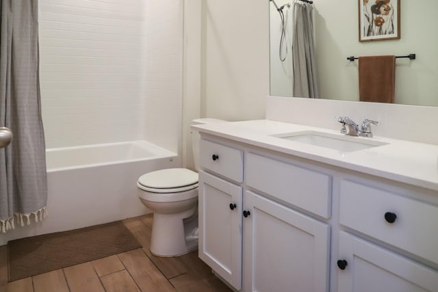 bathroom with shower / tub combo, wood finish floors, vanity, and toilet