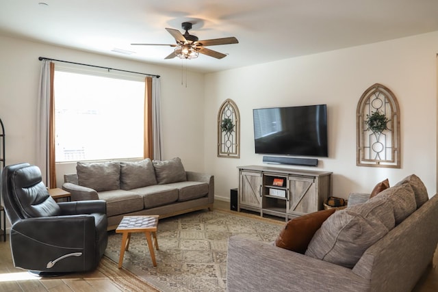 living room with ceiling fan, visible vents, and wood finished floors