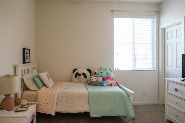 bedroom featuring dark carpet and baseboards