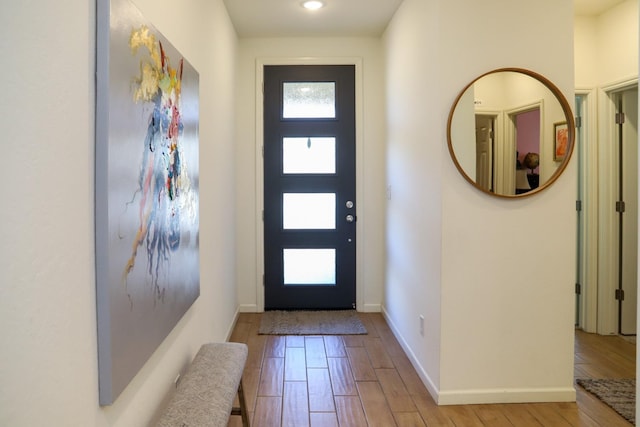 foyer with light wood-style floors and baseboards