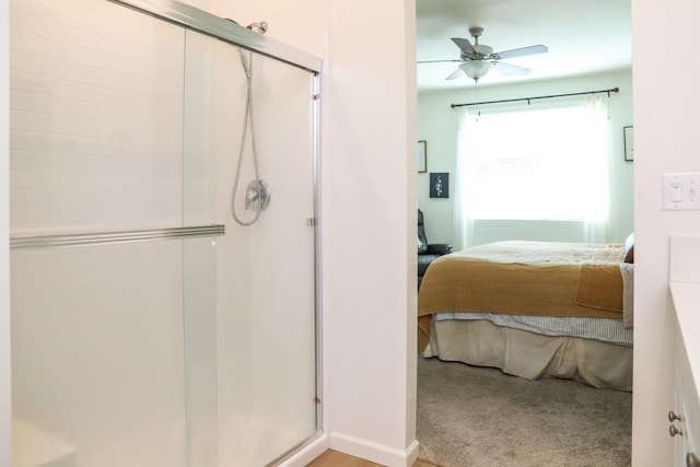 ensuite bathroom with a ceiling fan, a stall shower, and connected bathroom