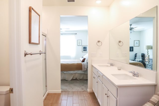 full bathroom featuring ensuite bath, ceiling fan, a sink, and wood finished floors