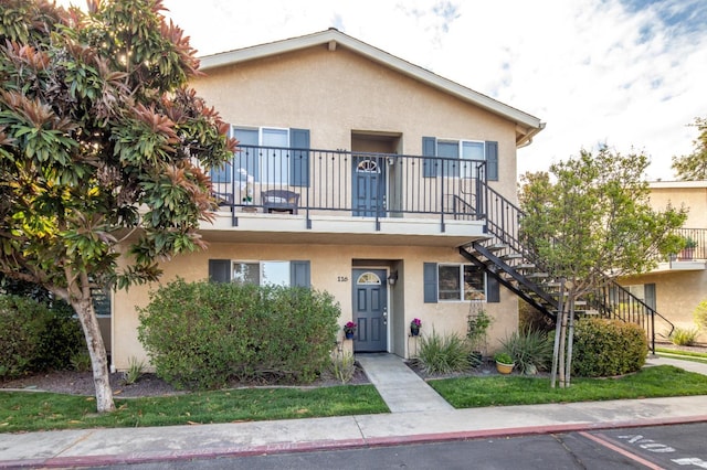 view of property featuring stairs and stucco siding