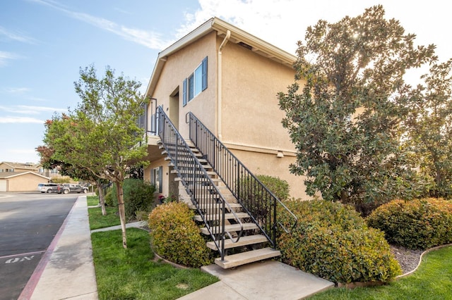 view of home's exterior with stairs and stucco siding