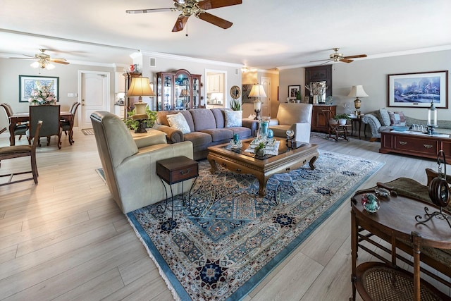 living room featuring light wood finished floors, a ceiling fan, and crown molding