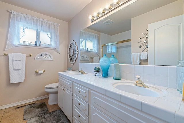 bathroom with double vanity, a stall shower, visible vents, tile patterned floors, and a sink