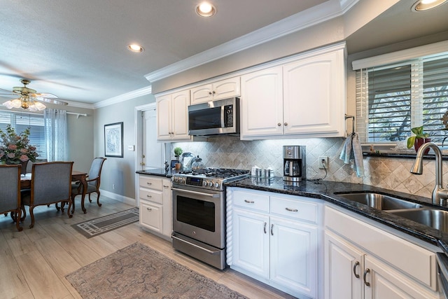 kitchen featuring tasteful backsplash, stainless steel appliances, ornamental molding, and white cabinets