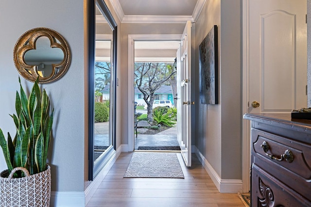 foyer entrance featuring light wood-type flooring, baseboards, and crown molding