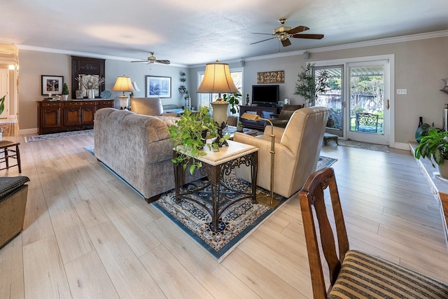 living area featuring ceiling fan, ornamental molding, light wood-style flooring, and baseboards