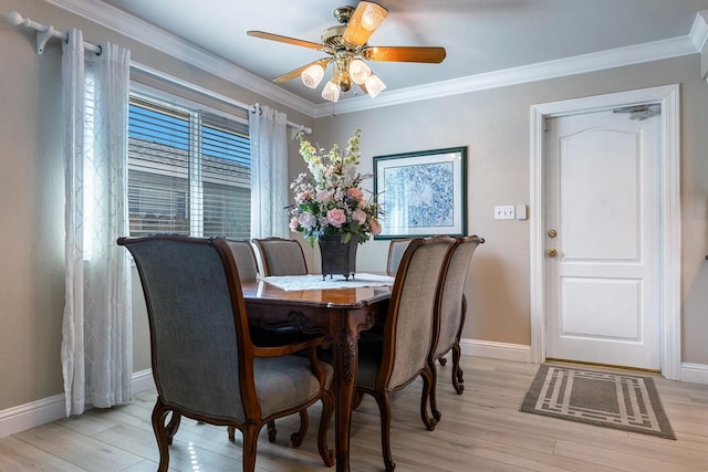 dining space featuring ornamental molding, light wood-type flooring, and baseboards