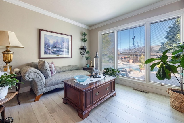 living room featuring light wood-type flooring, visible vents, and crown molding