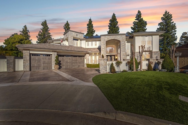 view of front of home featuring a garage, stone siding, concrete driveway, a lawn, and stucco siding