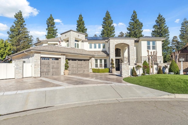 view of front of home featuring stone siding, fence, an attached garage, and solar panels