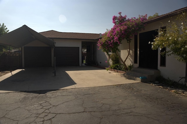 single story home with a garage, concrete driveway, and stucco siding