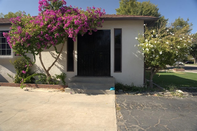 entrance to property featuring stucco siding