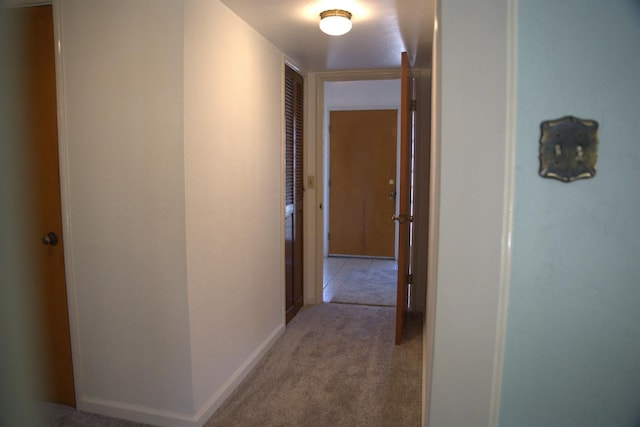 hallway featuring carpet flooring and baseboards