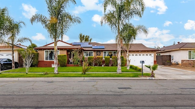 single story home with solar panels, an attached garage, a front yard, crawl space, and driveway