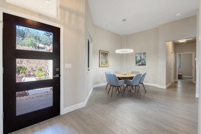 foyer featuring visible vents, baseboards, and wood finished floors