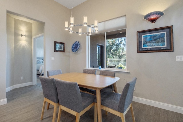 dining area featuring a notable chandelier, baseboards, and wood finished floors